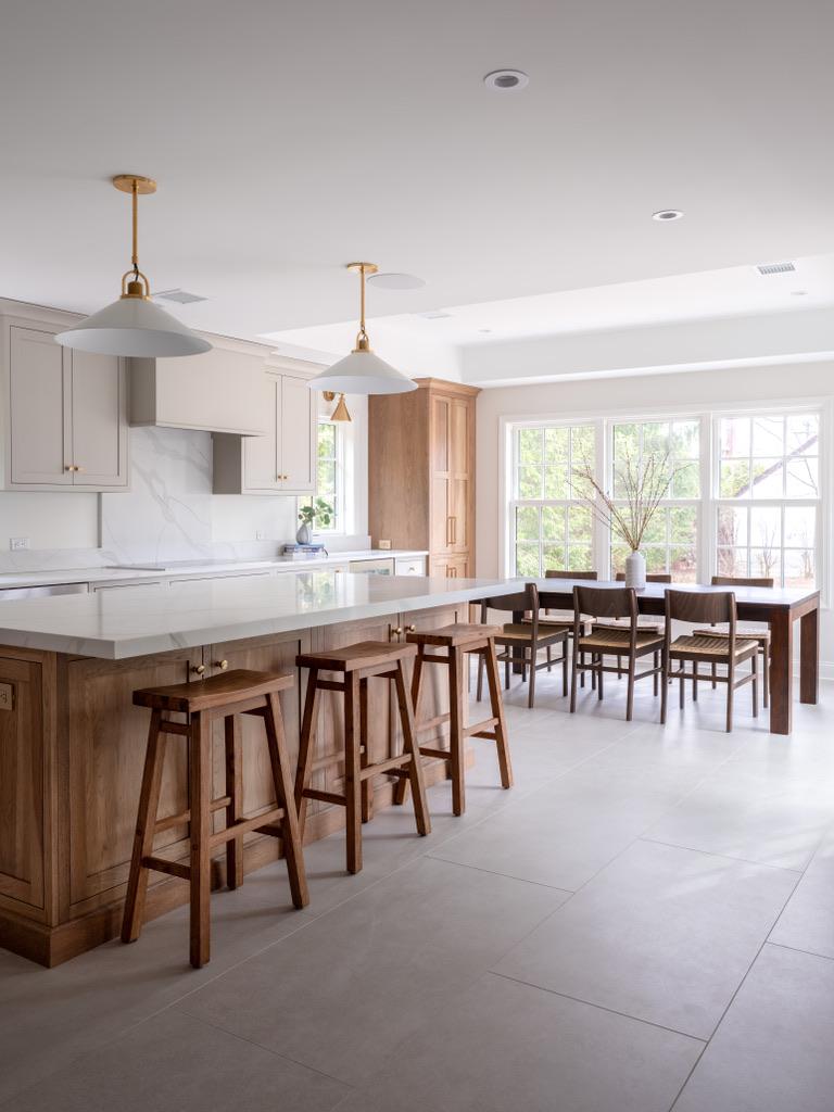 Bogert Home — view along the kitchen island and counter stools through to the walnut dining table beyond