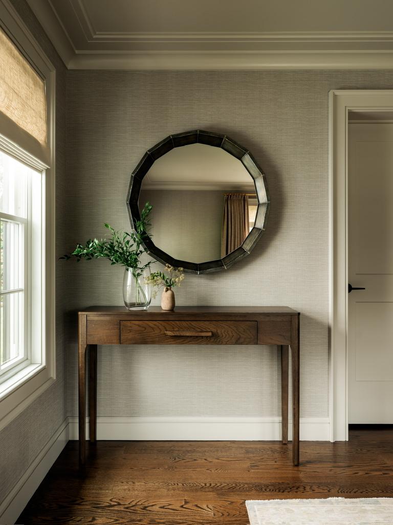 Monte Vista — entry console with a round faceted mirror against textured wallcovering