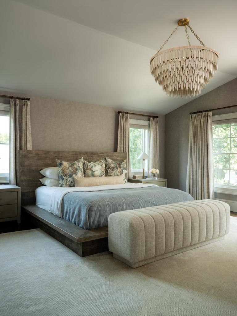 Monte Vista — primary bedroom with a wood platform bed, beaded chandelier and upholstered bench
