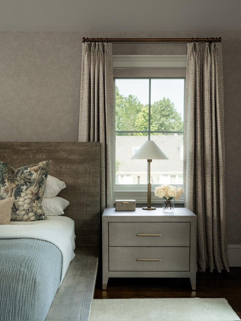 Monte Vista — bedside detail with a tapered table lamp and pleated drapery